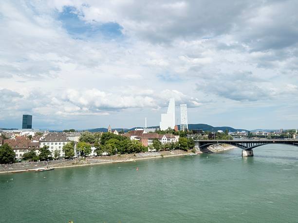istock Urban river view with bridge, buildings, and nature under a partly cloudy sky 2226430465