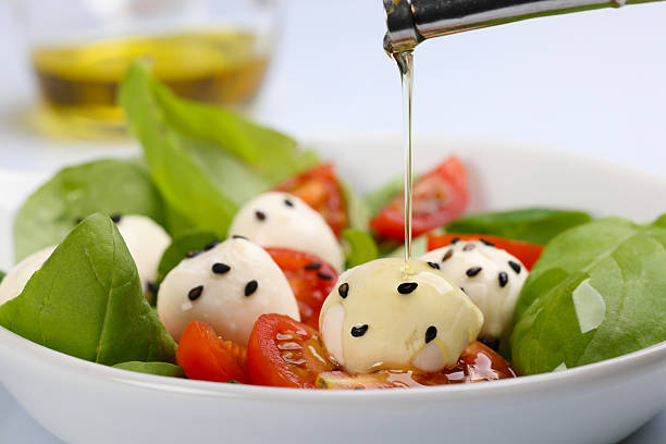 An overhead photo of a plate of Italian Caprese salad with Mozzarella cheese and cherry tomatoes, isolated on a white background with a clipping path