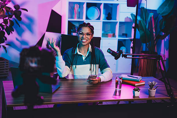 istock Young female vlogger recording content in a modern setup with neon lights and professional equipment 2226435566