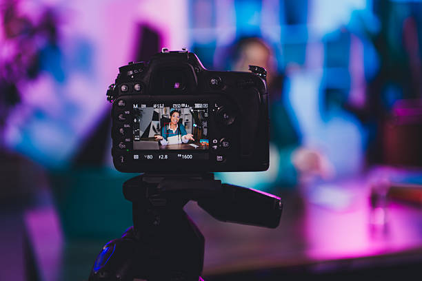 istock Professional female blogger recording content in neon-lit home office studio during evening with camera setup 2226435567