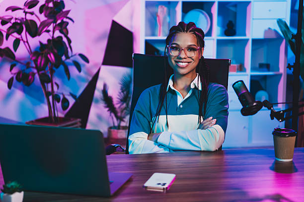 istock Radio host with braided hair sitting in a stylish workspace surrounded by modern decor during nighttime 2226435623