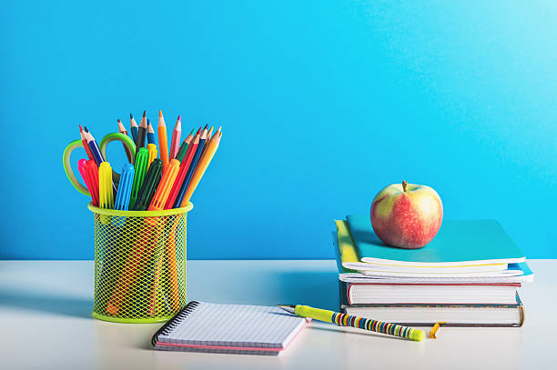 istock A stack of books, a stand with pencils and pens and an open notebook on a blue background. Back to school, teacher's day. 2226437246