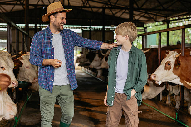istock Farmer and son sharing a moment in cow barn 2226442041