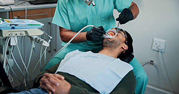 Man, patient and dentist cleaning mouth with tools for bacteria or germ removal at orthodontist. Male person, client or teeth surgeon with suction for tooth extraction, dental or oral care at clinic Man, patient and dentist cleaning mouth with tools for bacteria or germ removal at orthodontist. Male person, client or teeth surgeon with suction for tooth extraction, dental or oral care at clinic oral surgeon stock pictures, royalty-free photos & images