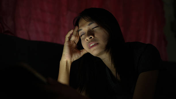 istock Woman appears to be experiencing stress or fatigue while using device in dimly lit room. soft light illuminates her face, highlighting her expression of exhaustion 2226452151