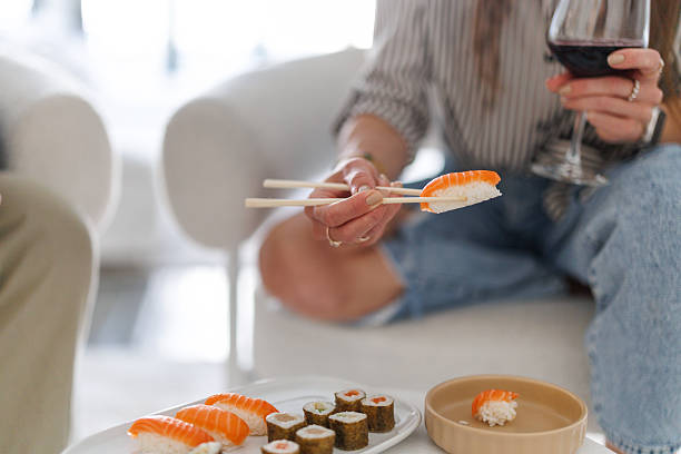 istock Friends Sharing Sushi and Wine in Cozy Setting 2226452357