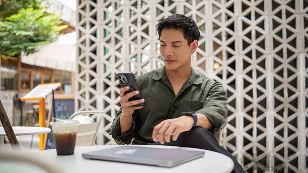 istock Confident businessman checking messages on mobile phone while relaxing at a coffee shop. 2226456233