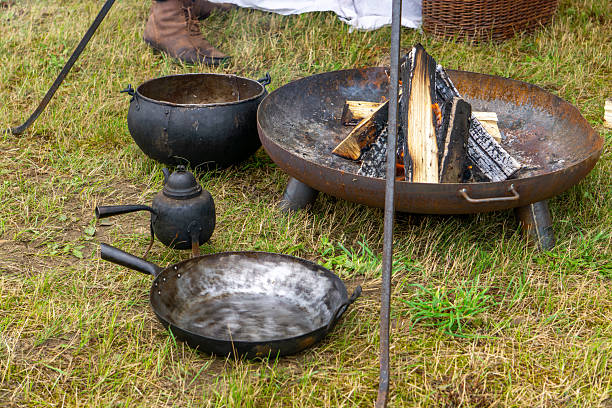 istock Campfire with cast iron pot, pan, and kettle, part of a historical reenactment scene. 2226457840