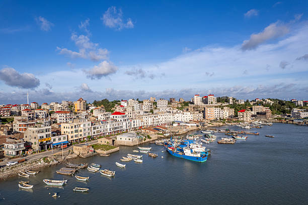 istock Coastal village harbor with boats under a blue sky. 2226458164