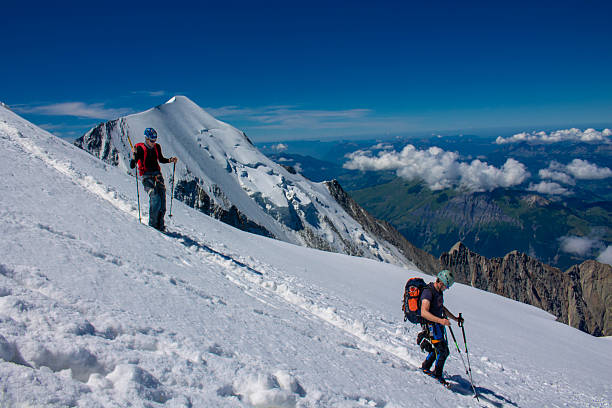 Chamonix, France - 8 August 2024: Climbers ascending Mont Blanc in daylight alpine landscape snowy mountain ridge outdoor adventure high altitude glacier mountaineering gear highest European peak scenery