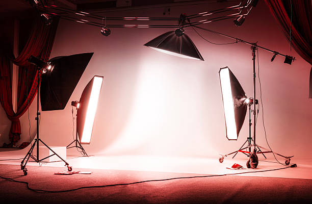 istock Red photo session studio. Professional sports background for advertisement. Workspace interior with grey backdrop, backstage and lamps 2226458577