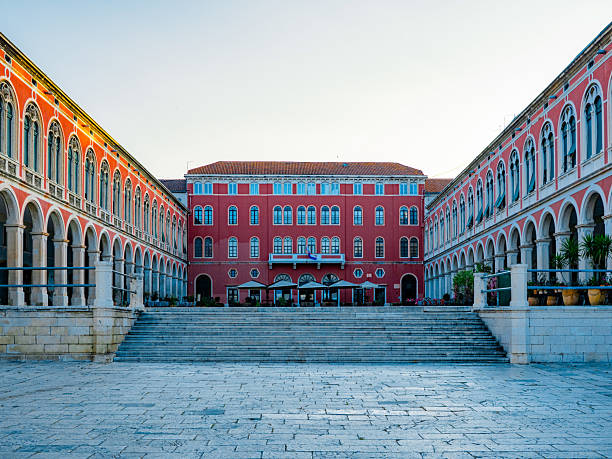istock Trg Republike in Split, Croatia, features vibrant red neoclassical facades and elegant arches 2226461409
