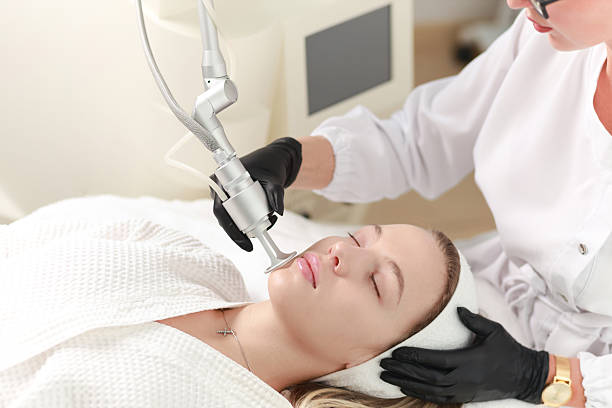 CO2  carbon dioxide laser resurfacing procedure in a Beauty spa salon. Professional dermatologist doctor working on a client. Hardware cosmetology procedure.