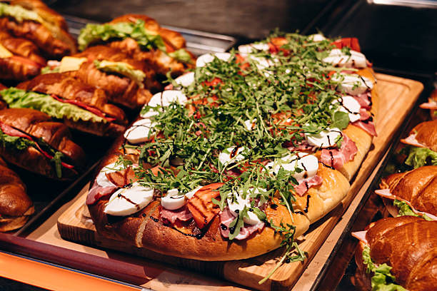 istock Pie with arugula, mozzarella, tomato, and meat on bakery display. 2226467110