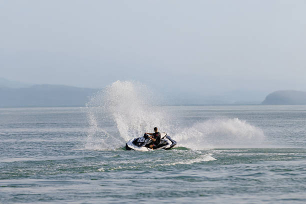 istock Man riding a jet ski across the water 2226469310
