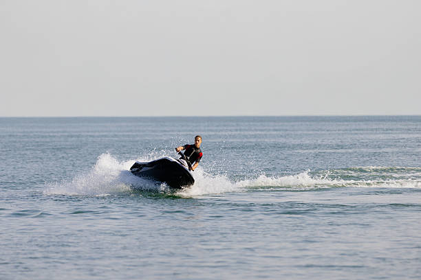 istock Young man rides a jet ski across turquoise waters during seaside vacation. 2226469311