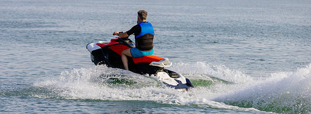 istock Young man speeds on a jet ski under the bright summer sun. 2226469342