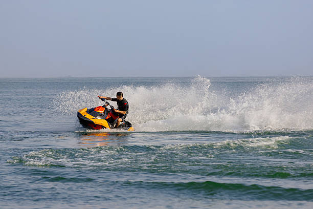 istock Man riding a jet ski across the water 2226469365