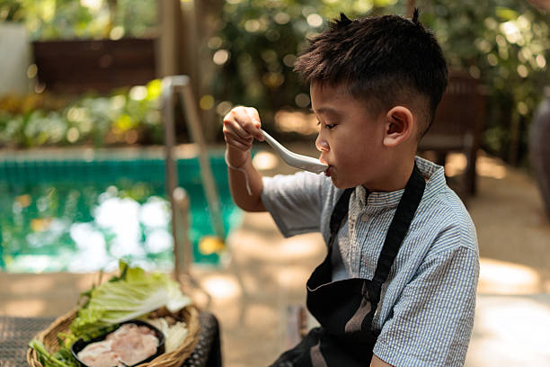 istock Young boy enjoying soup during family barbecue 2226471387