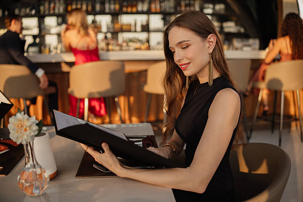 istock Elegant woman choosing dish from menu 2226471870
