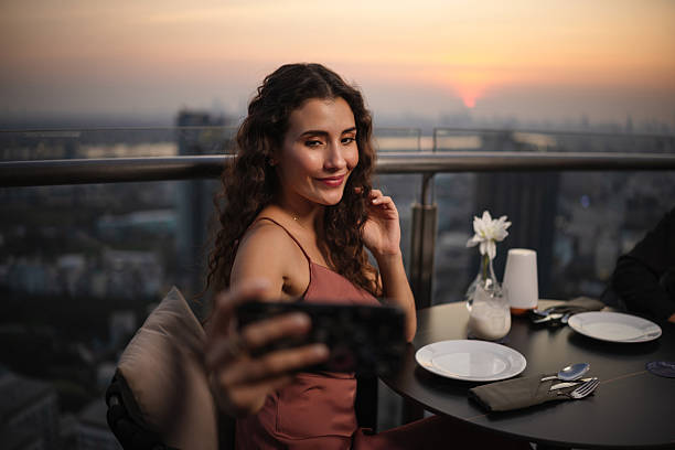 istock Elegant woman taking a selfie at rooftop restaurant 2226472114