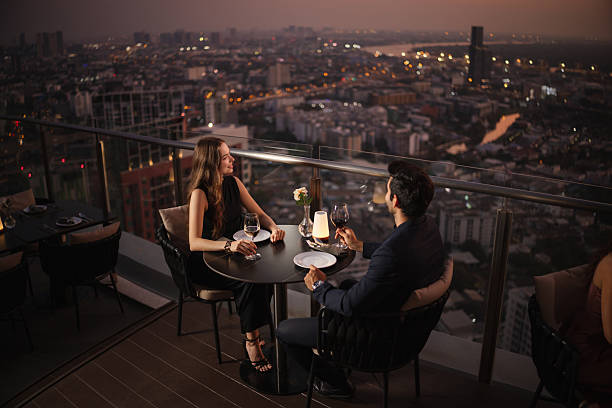 istock Couple enjoying the city view from a rooftop restaurant 2226472166