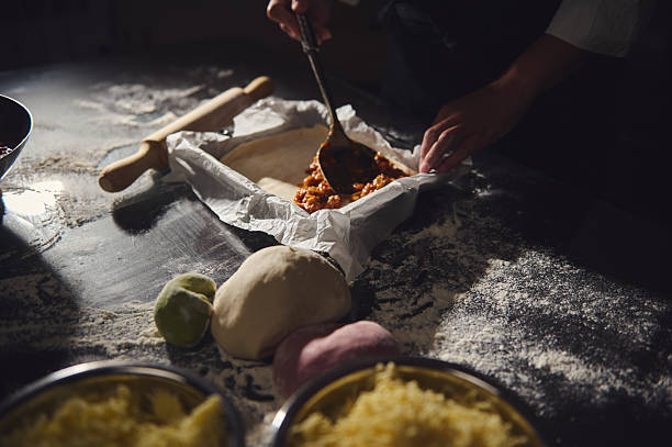 Artisan Preparing Dough and Filling for a Savory Dish in Rustic Setup