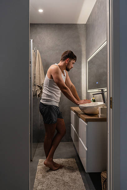 istock Young man standing in front of a bathroom mirror 2226475121