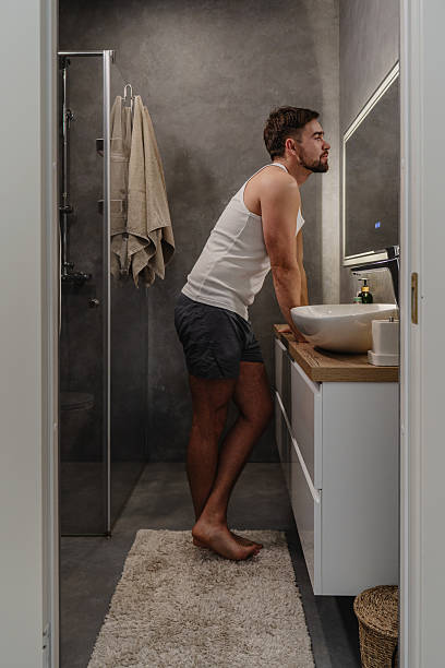 Young man standing in front of a bathroom mirror