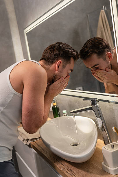istock Man Washing Face with Water at Bathroom Sink 2226475309