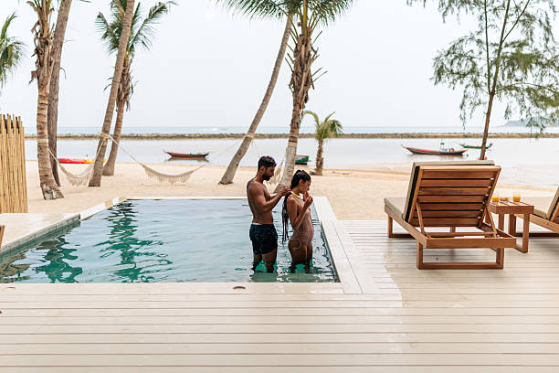 istock Romantic couple standing in a pool with tropical beach in the background 2226475312