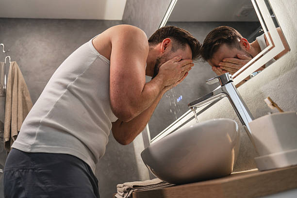 istock Man Washing Face with Water at Bathroom Sink 2226475346