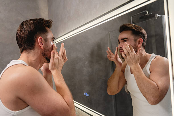istock Man applying under eye patches in front of a bathroom mirror 2226476503
