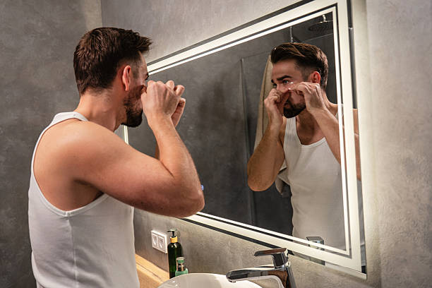 istock Man applying under eye patches in front of a bathroom mirror 2226476687