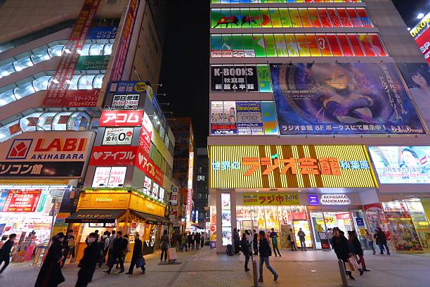 People visit Akihabara district of Tokyo by night. Akihabara district is known as Electric Town district, it has reputation for electronics stores and otaku culture.