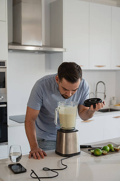 istock Man Blending Fresh Homemade Smoothie in Modern Kitchen 2226478989
