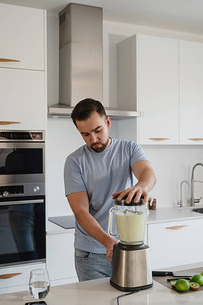 istock Man Blending Fresh Homemade Smoothie in Modern Kitchen 2226479078