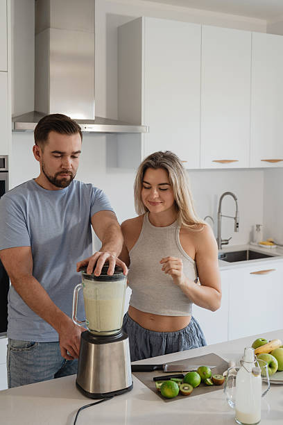 istock Couple Preparing Healthy Smoothie Together in Bright Modern Kitchen 2226479407
