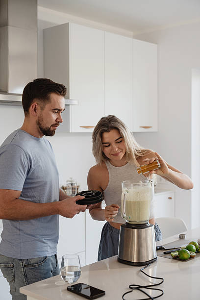 istock Couple Preparing Healthy Smoothie Together in Bright Modern Kitchen 2226479472