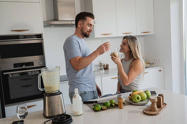 istock Couple Enjoying Homemade Smoothie Together in Modern Kitchen 2226479842