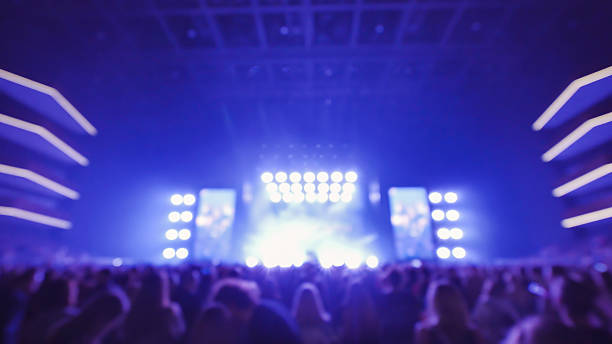 istock Crowd enjoying live music concert with bright lights at night 2226483583
