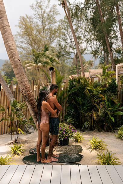 istock Couple refreshing under a natural bamboo shower on the beach 2226484208