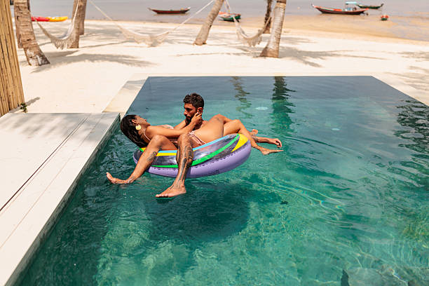 istock Romantic couple floating on inflatable ring in tropical pool 2226485304
