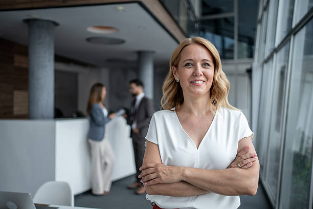 istock Confident businesswoman smiling with folded arms in modern office 2226486728