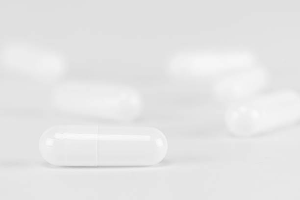 istock White capsule pill on a clean, bright background. Minimalist concept for medical science, pharmaceutical research, or a generic drug. Focus on a single dose of medicine for healthcare or treatment. 2226489084