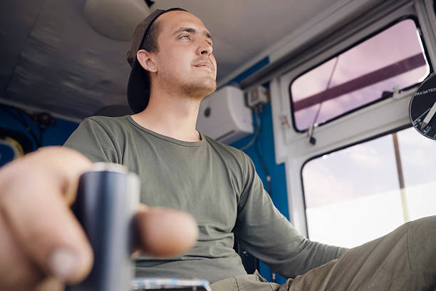 istock A crane operator expertly maneuvers a joystick inside the cabin of a crane, focused on overseeing construction tasks. The operator, wearing casual work attire and a cap, showcases concentration as he manages heavy equipment. 2226489720