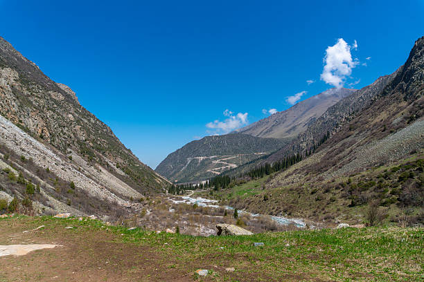 istock Ala-Archa Park Mountain landscape featuring steep slopes, rocky terrain. Flowing river, winding trail. lush vegetation, distant peaks. Trekking, hiking, mountaineering. Adventure travel, exploration 2226492597