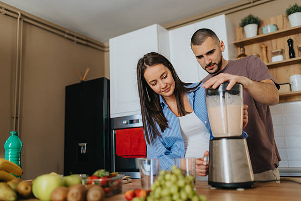 istock Happy couple preparing healthy fruit smoothie at home 2226495616