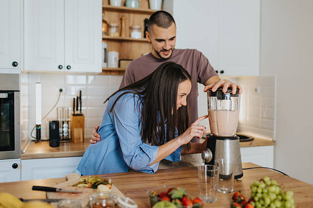 istock Happy couple preparing healthy fruit smoothie at home 2226495689