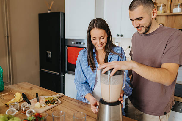 istock Happy couple preparing healthy fruit smoothie at home 2226495824